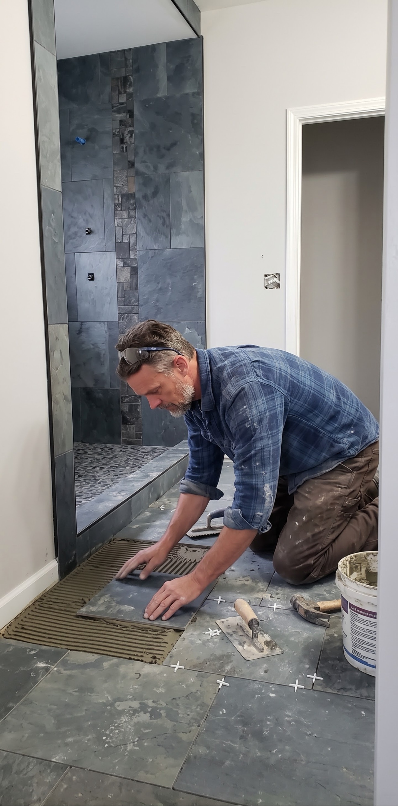 Simon laying a slate bathroom floor